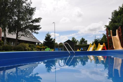 a swimming pool with a bunch of playground equipment at Apartamenty Beata w Sasinie in Sasino