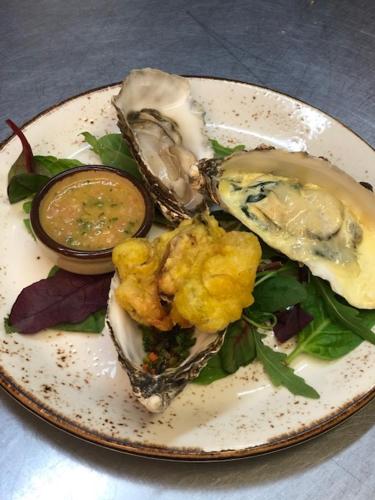 a plate of food with oysters and sauce on it at Port Charlotte Hotel in Port Charlotte