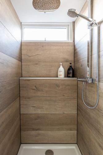a bathroom with a shower with wooden walls at SEA MORE in Zandvoort