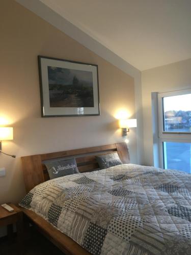 a bedroom with a bed and two lamps and a window at Ferienwohnung Stella Maris in Glowe