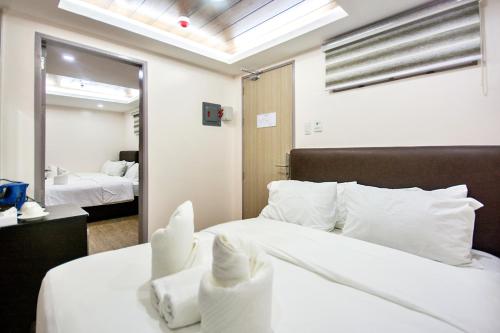 a bedroom with a large white bed and a mirror at Emerald Island Hotel in Boracay