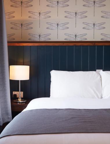 a bedroom with a bed and a blue wall at Sun Inn in Eastwood