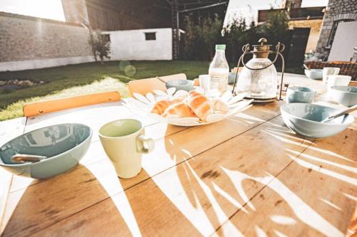 une table avec des bols et des assiettes de nourriture dans l'établissement La Grange de Séverine, à Cauroy-lès-Hermonville