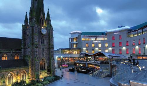 ein Gebäude mit einem Uhrturm neben einem Gebäude in der Unterkunft Crowne Plaza Birmingham City, an IHG Hotel in Birmingham