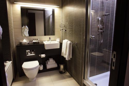 a bathroom with a toilet and a sink and a shower at Crowne Plaza Birmingham City by IHG in Birmingham