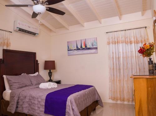 - une chambre avec un lit et un ventilateur de plafond dans l'établissement Sweet Holiday Haven, à Ocho Rios