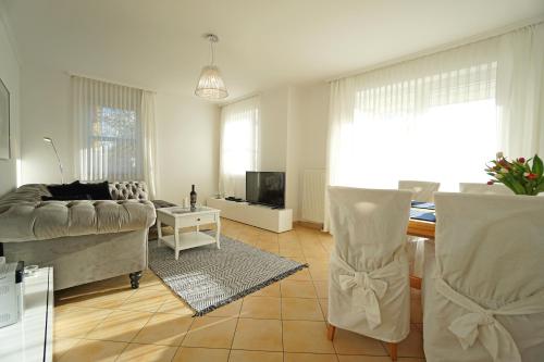 - un salon avec un canapé et une télévision dans l'établissement Villa Madeleine Wohnung 6, à Bansin