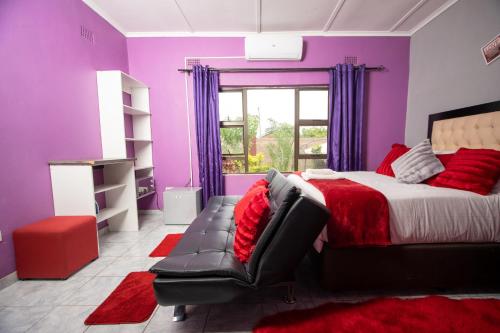 a purple bedroom with a bed and a chair at Sweet Holiday Homes in Victoria Falls