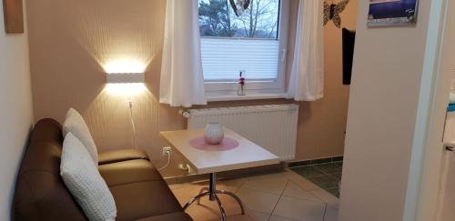 sala de estar con sofá, mesa y ventana en Ferienwohnung Kroll, en Ahlbeck