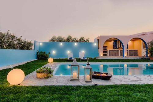 a backyard with a swimming pool and a house at Afandou Beach Villas Sofias in Afantou