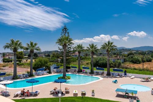 a pool at a resort with palm trees at Sabina Hotel in Theologos