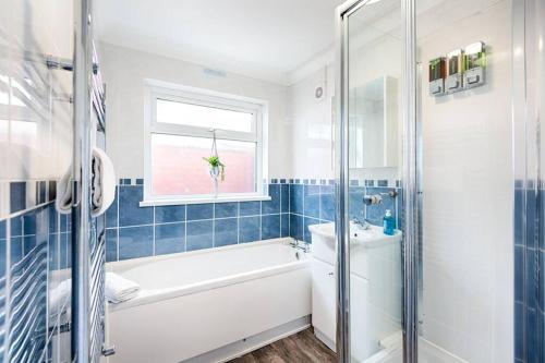 a bathroom with a bath tub and a sink at Great base in Swansea! in Swansea