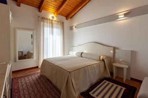 1 dormitorio con 1 cama grande y espejo en Le Ginestre en Massa