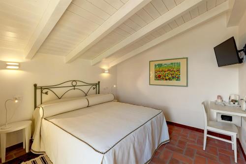 a bedroom with a white bed and a desk at Le Ginestre in Massa