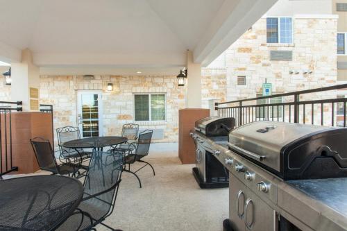 un patio con parrilla, mesa y sillas en Candlewood Suites New Braunfels, an IHG Hotel, en New Braunfels