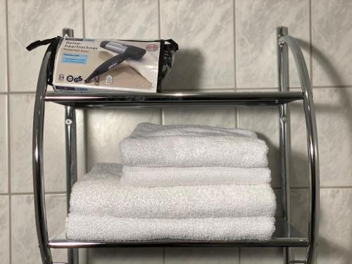 una pila de toallas en un estante del baño en Budget Pension Plauen, en Plauen