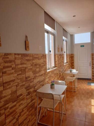 Habitación con mesas, sillas y pared de ladrillo. en Why Not? Guest House Espinho, en Espinho