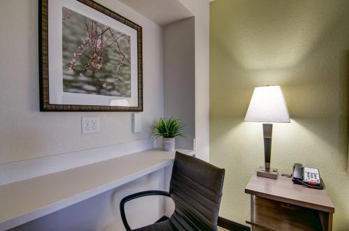 a hotel room with a desk and a chair and a lamp at Candlewood Suites Richmond - West Broad by IHG in Richmond