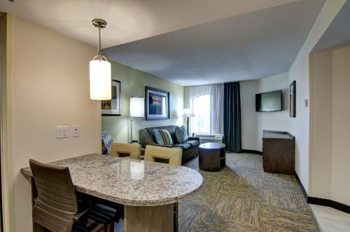 a living room with a table in a hotel room at Candlewood Suites Richmond - West Broad by IHG in Richmond