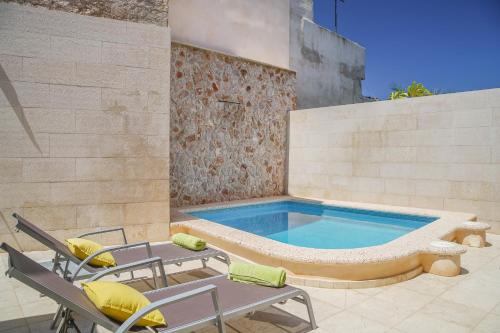 a swimming pool with chairs and a table and a pool at Holiday Home Ribot in Ariany