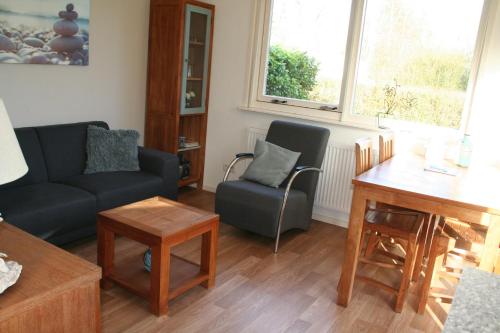 - un salon avec un canapé et une table dans l'établissement Rekerlanden 257, à Schoorldam
