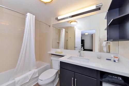 a bathroom with a sink and a toilet and a tub at Candlewood Suites Sayre, an IHG Hotel in Sayre