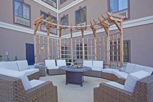 a patio with chairs and a table in a building at Staybridge Suites Houston Stafford - Sugar Land by IHG in Stafford