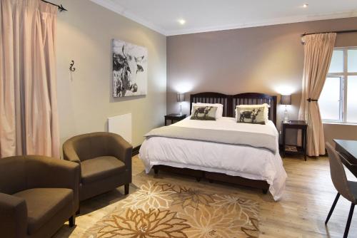 a bedroom with a bed and a desk and a chair at Sandown Guest House in Johannesburg