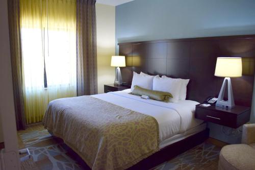 a hotel room with a large bed and a window at Staybridge Suites Houston Stafford - Sugar Land by IHG in Stafford