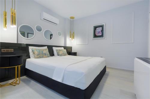 a bedroom with a white bed and a table at Twin Apart Hotel in Alanya