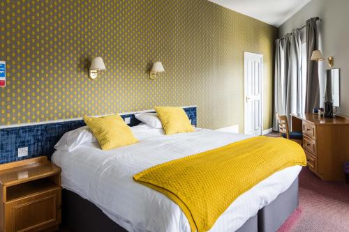 a bedroom with a white bedspread and pillows at THE DONARD in Newcastle