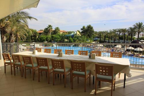 a table and chairs with a view of a pool at AQI Pegasos World in Side