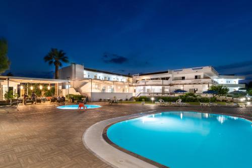 una piscina frente a un edificio por la noche en Sabina Hotel, en Theologos