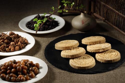 a table with cookies on a plate and plates of food at HUALUXE Yangjiang City Center in Yangjiang