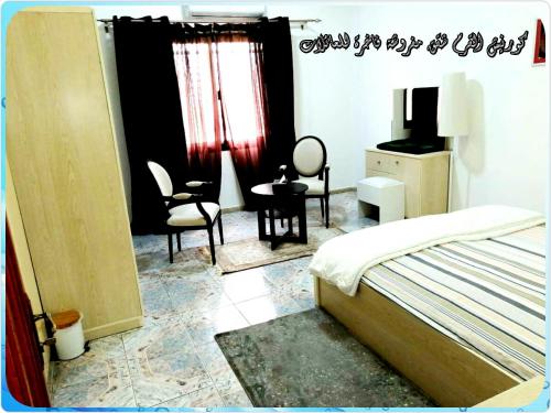 1 dormitorio con 1 cama, mesa y sillas en Mangrove Corniche Families Luxury Furniture Apartments, en Abu Dabi