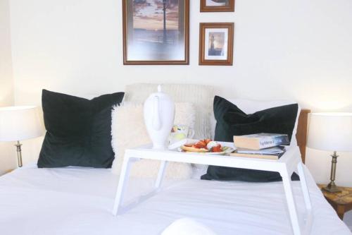 a white table with a plate of food on a bed at Kikas Cottage, Rear 89 Church Street, White Horse Yard in Whitby