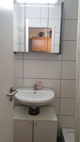 a bathroom with a white sink and a mirror at Workers-Sleep-Station in Cologne