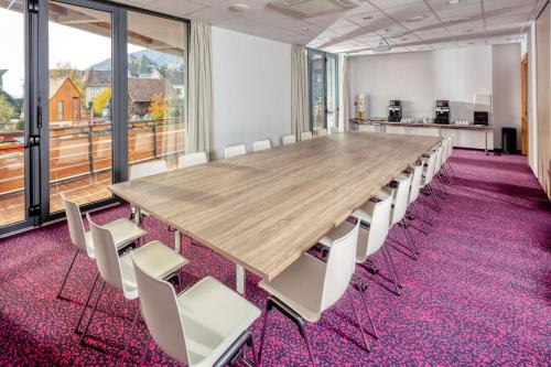 a large conference room with a large wooden table and chairs at Best Western Plus Hotel & SPA Le Schoenenbourg in Riquewihr