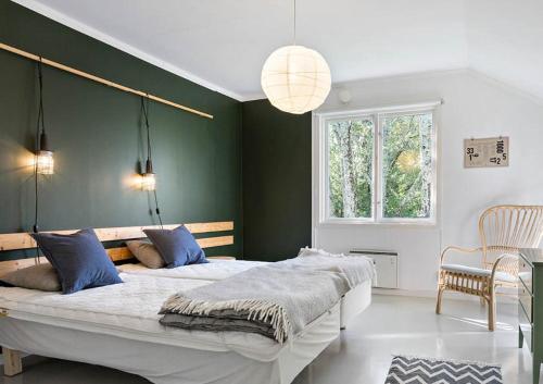 um quarto com uma cama grande e uma parede verde em Sågverket Höga Kusten em Rö