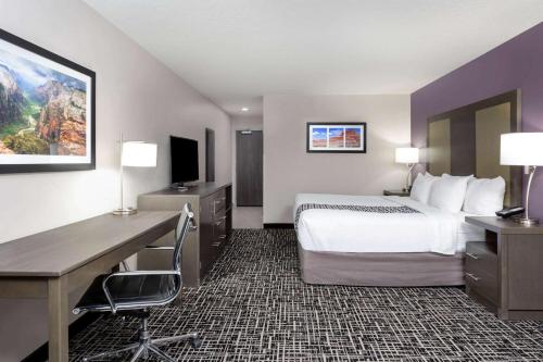 a hotel room with a bed and a desk and a computer at La Quinta by Wyndham Kanab in Kanab