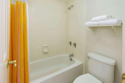 a bathroom with a white toilet and a tub and a sink at La Quinta Inn by Wyndham Cheyenne in Cheyenne