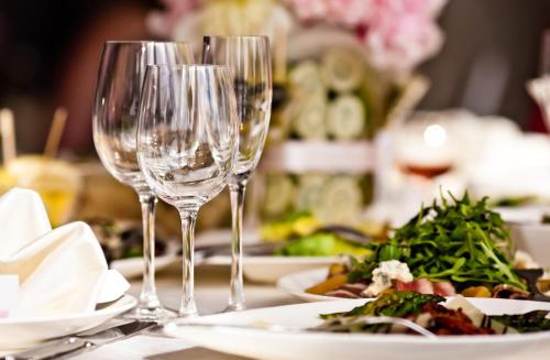 a table with wine glasses and plates of food at Hotel Marc Aurel in Petronell