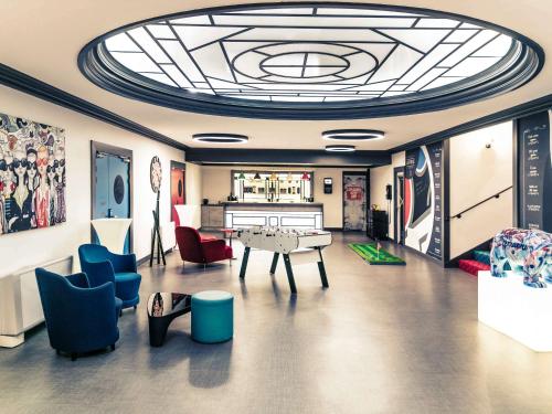 a living room with a ping pong table and chairs at Mercure Lyon Centre Château Perrache in Lyon