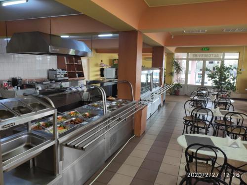 una gran cocina con mesas y sillas en un restaurante en Hotel Turist Beharca en Beharca
