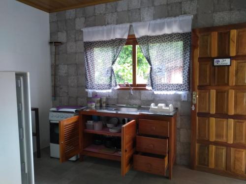 a kitchen with a sink and a window at Condomínio Ypê Casas Maringá MG in Visconde De Maua