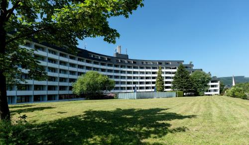 ein großes Gebäude mit einem Feld davor in der Unterkunft Sauerland Stern Hotel in Willingen