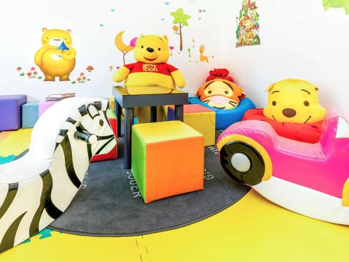 a room with stuffed winnie the pooh toy cars at Novotel Bangkok IMPACT in Nonthaburi