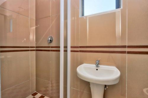 a bathroom with a sink and a shower at African Sun lodge in Durban