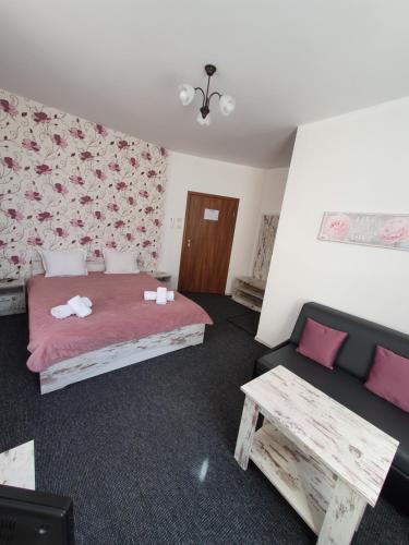 a bedroom with a bed and a couch and a table at Guest House Gurkov in Veliko Tŭrnovo