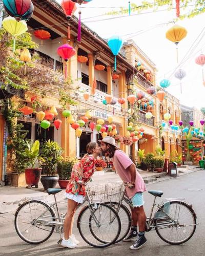 a man and a woman standing next to a bike at Cherry Garden Homestay in Hoi An